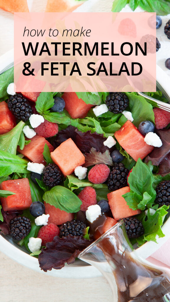 In a white bowl, a green salad has cubes of watermelon, fresh blackberries, fresh blueberries, chunks of feta and a balsamic dressing. Next to the bowl is the fruit. 