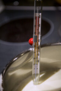 Image of candy thermometer in a saucepan with milk