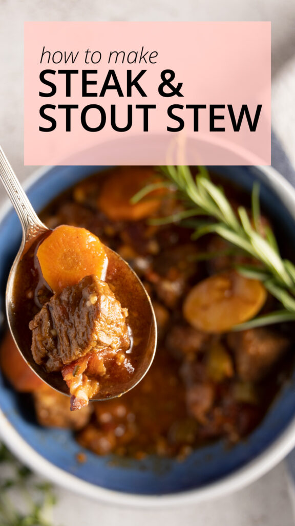 An overhead view of a bowl of beef stew, showing carrots, potatoes, and beef. A spoon rests in the bowl. Next to the bowl are fresh thyme and rosemary sprigs, and a blue and white striped towel.