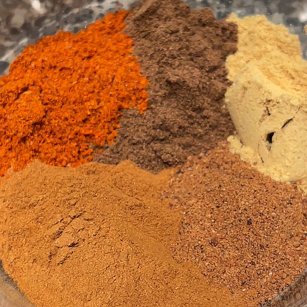 A grouping of spices used in the recipe for holiday spiced nuts.