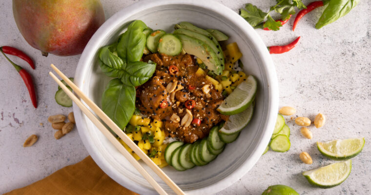 Saucy chicken on top of rice, topped with fresh basil, avocado, mango salsa and sliced cucumbers.