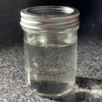 A mason jar containing clear simple syrup