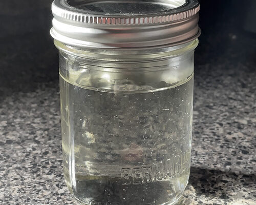 A mason jar containing clear simple syrup