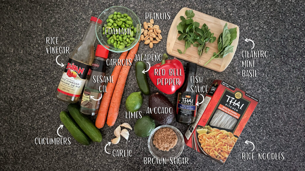 All of the ingredients used in making a Spring roll in a bowl are arranged on a counter. Each item is labelled. 