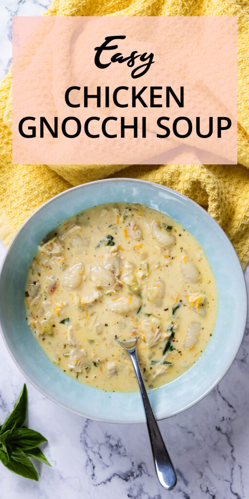A bowl of creamy chicken & gnocchi soup, with a spoon and a yellow towel.