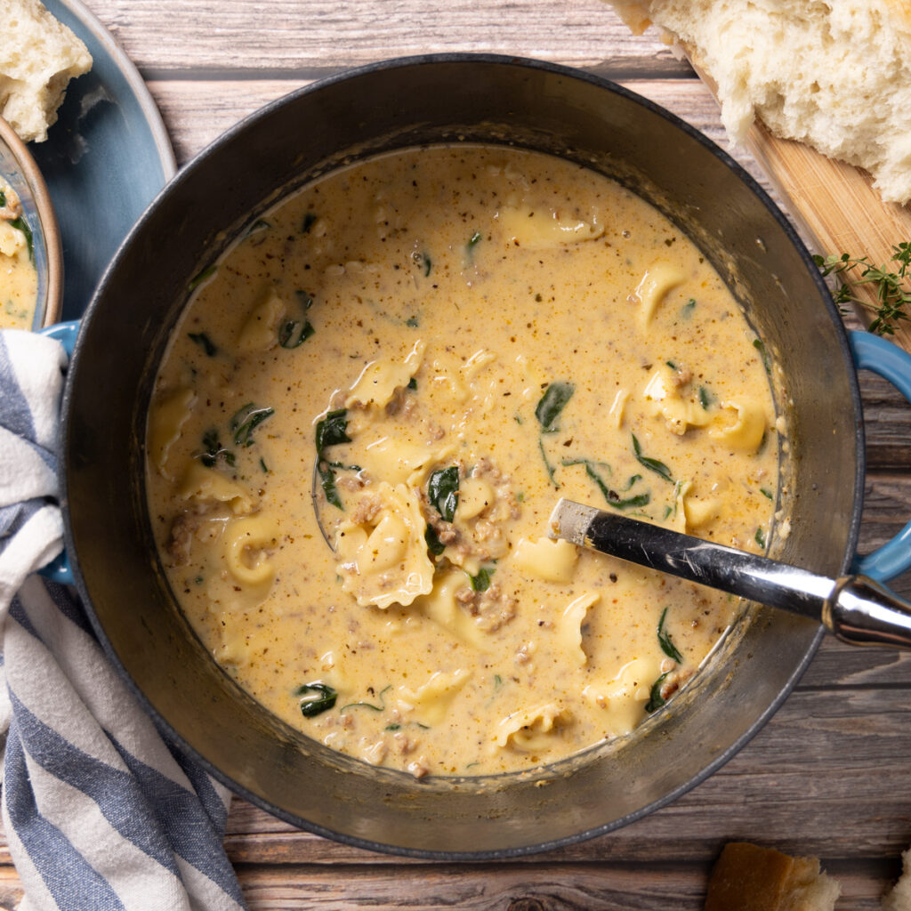 A pot of creamy sausage, spinach, and tortellini soup.