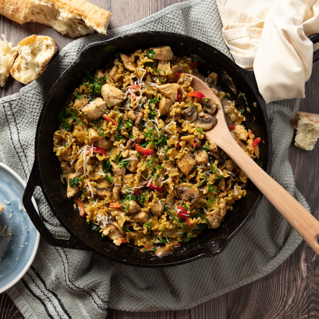 A skillet with a creamy chicken and mushroom pasta recipe.