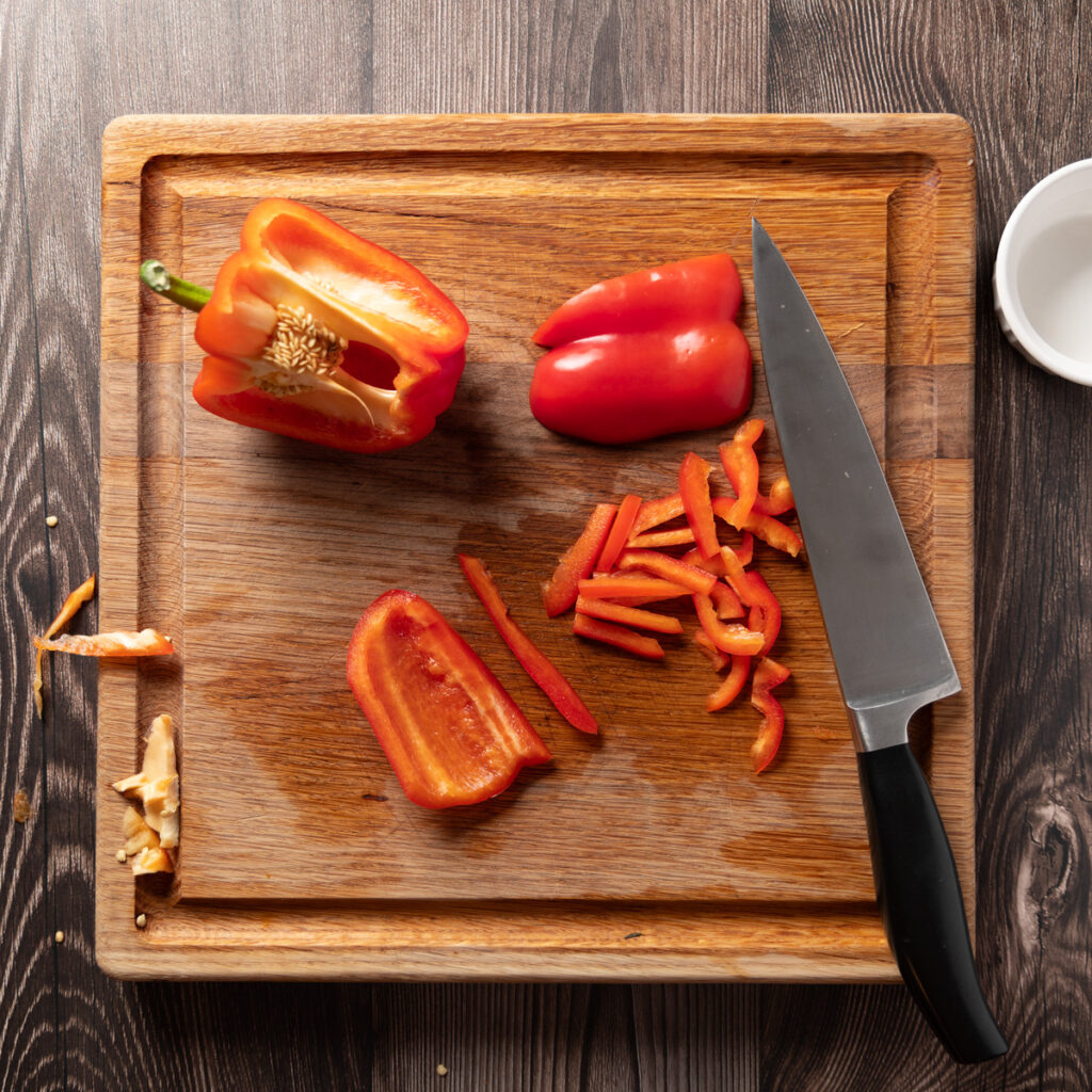 Slicing red bell peppers.