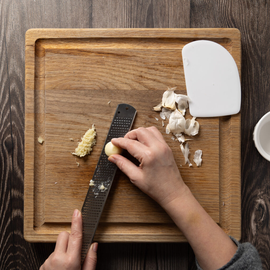 Mincing garlic using a microplane grater.