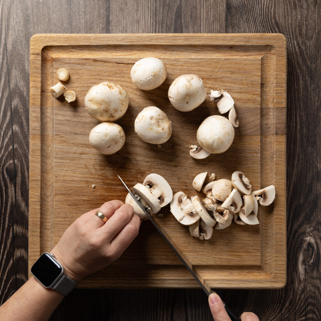 Slicing white button mushrooms.