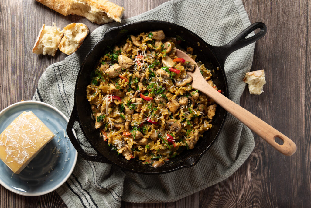 A skillet with a creamy chicken and mushroom pasta recipe.