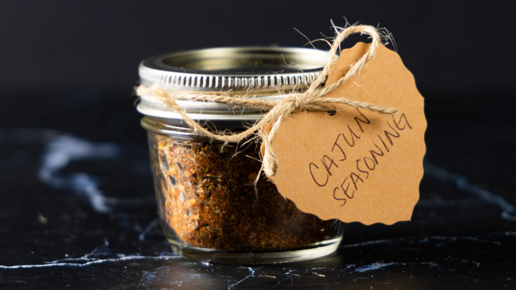 A jar of homemade Cajun Seasoning with a hand-made label.