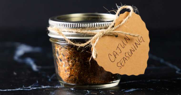 A jar of homemade Cajun Seasoning with a hand-made label.