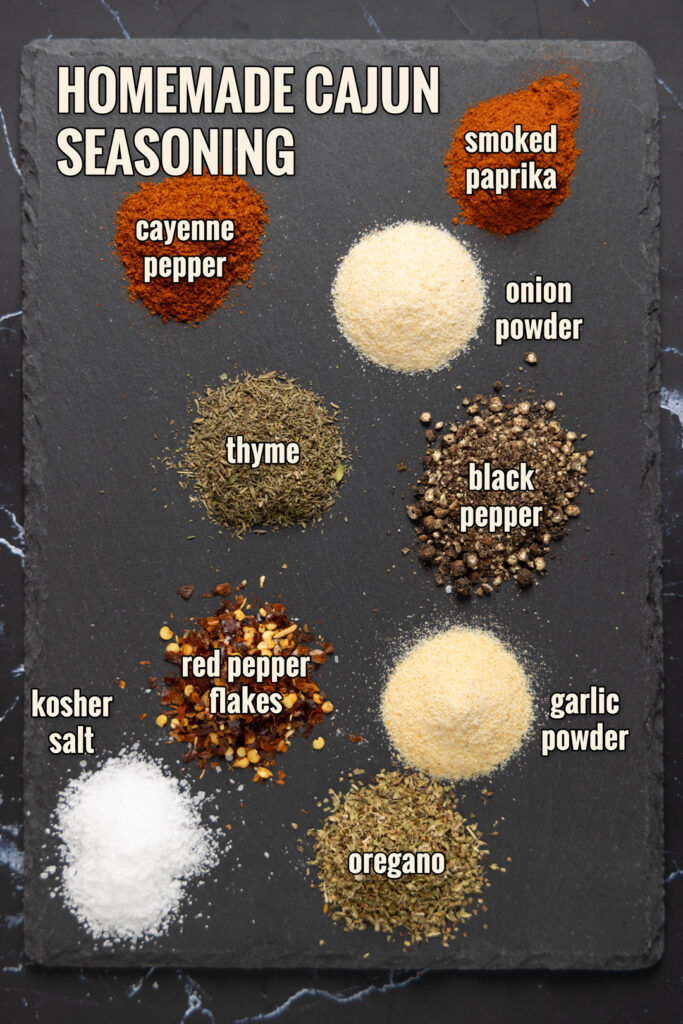 Ingredients to make Homemade Cajun Seasoning are arranged on a slate.