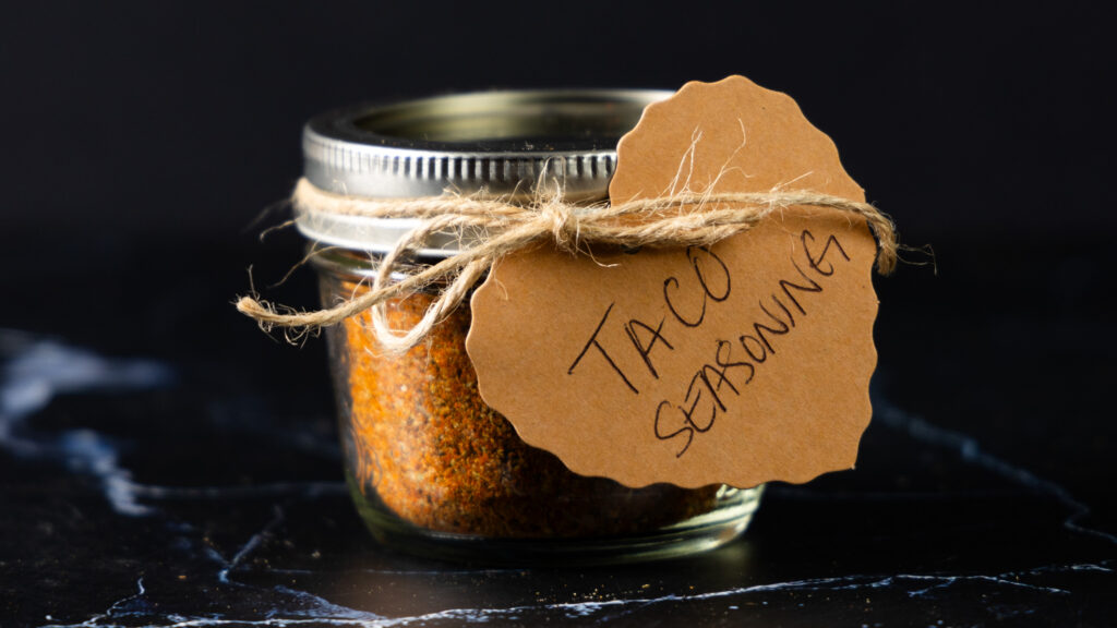 A jar of homemade Taco Seasoning with a hand-made label.