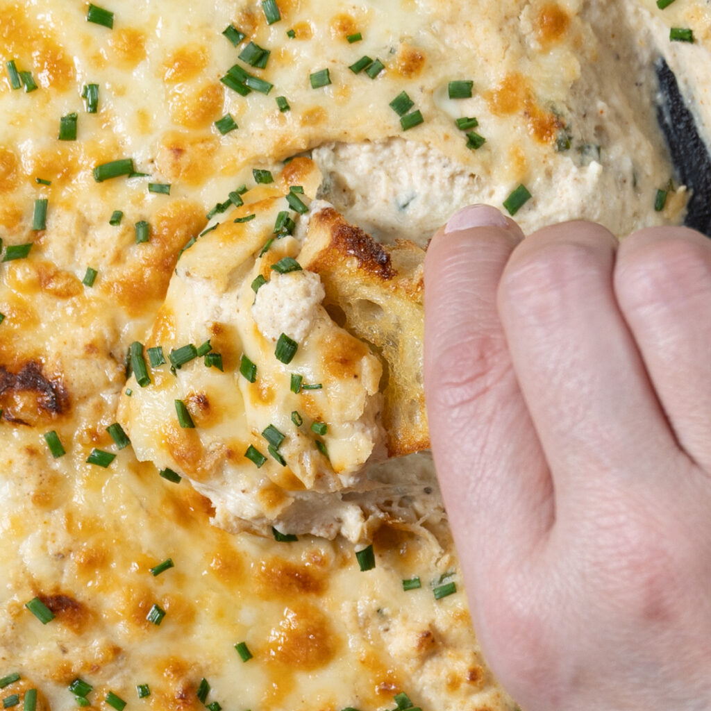 A cast-iron skillet with hot and cheesy crab dip.