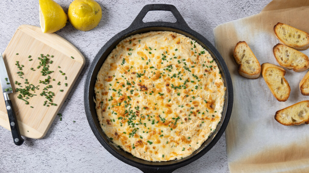 A cast-iron skillet with hot and cheesy crab dip.