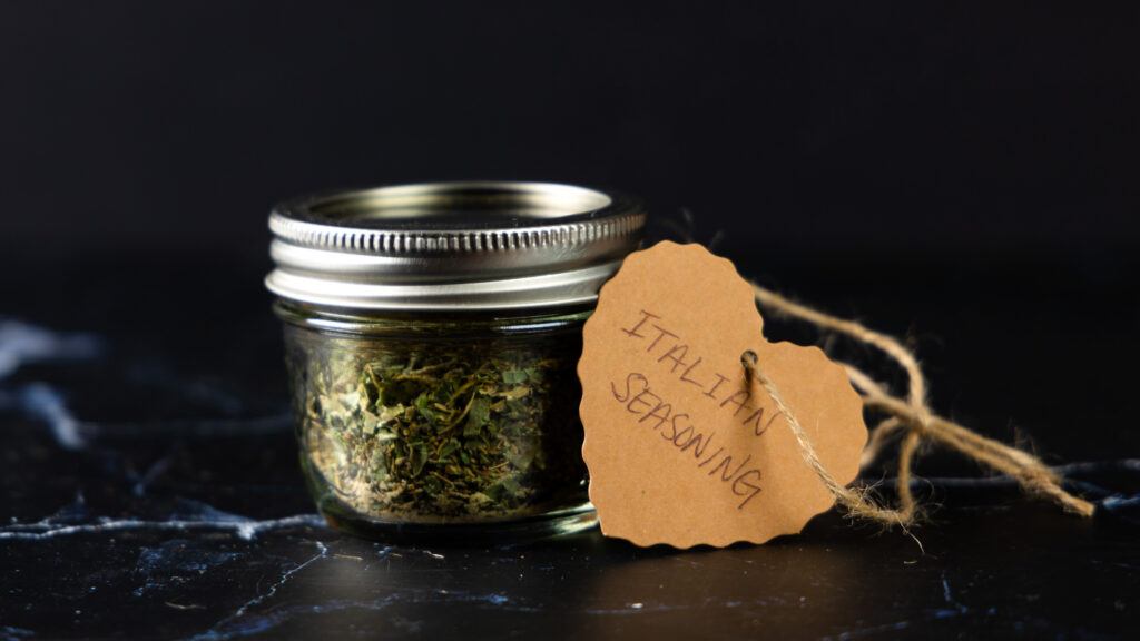 A jar of homemade Italian Seasoning with a hand-made label.