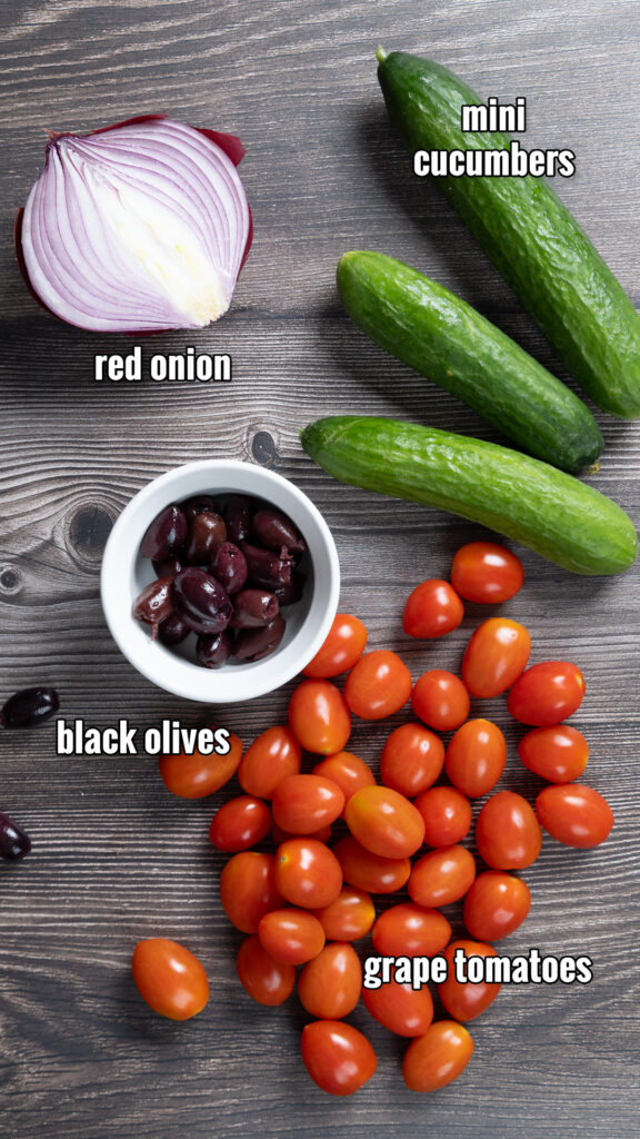 The ingredients for Greek salad, arranged on a counter.