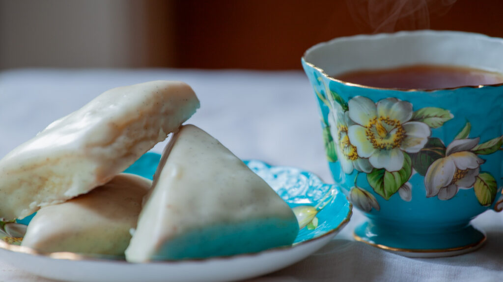 Petite Vanilla Bean Scones on a plate, with a cup of tea.