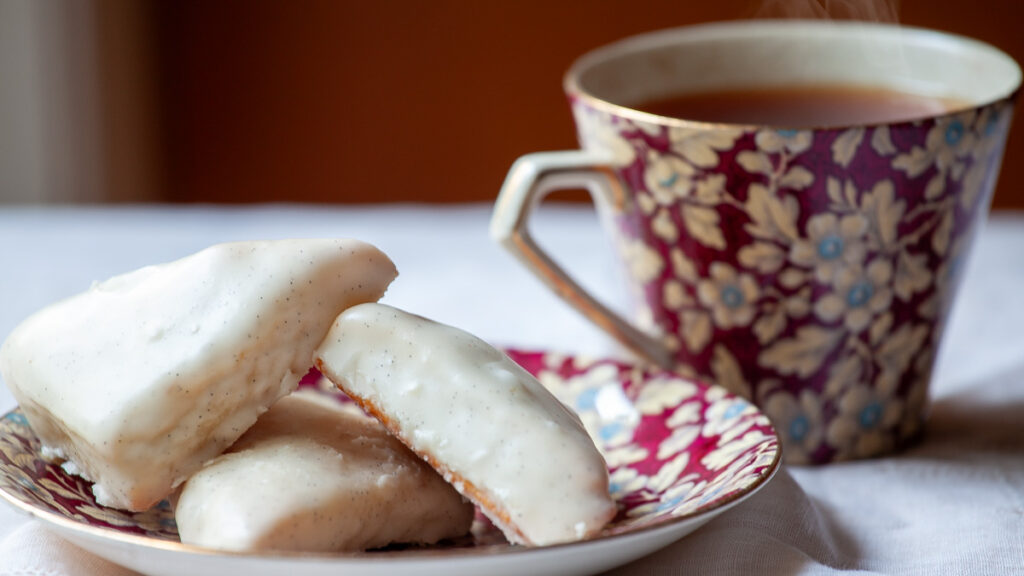 Petite Vanilla Bean Scones on a plate, with a cup of tea.