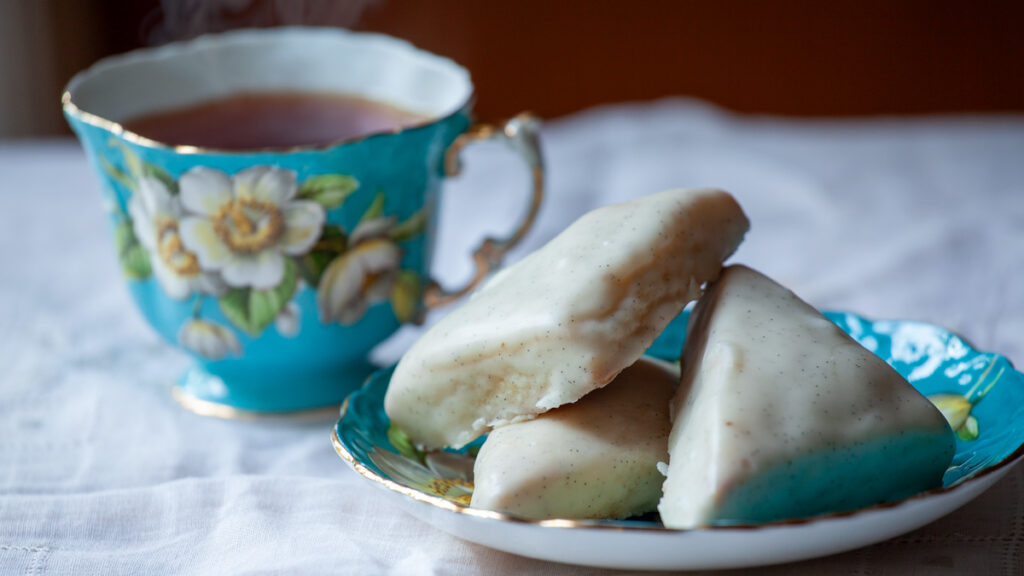 Petite Vanilla Bean Scones on a plate, with a cup of tea.