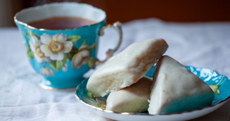 Petite Vanilla Bean Scones on a plate, with a cup of tea.