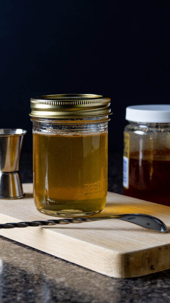 A mason jar contains Honey Simple Syrup.