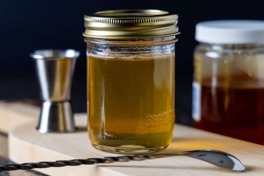 A mason jar contains Honey Simple Syrup