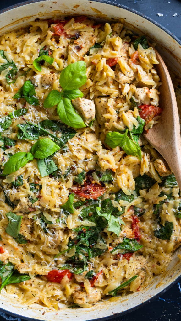 A skillet contains an orzo dish with a creamy sauce: One Pan Creamy Boursin Chicken Orzo