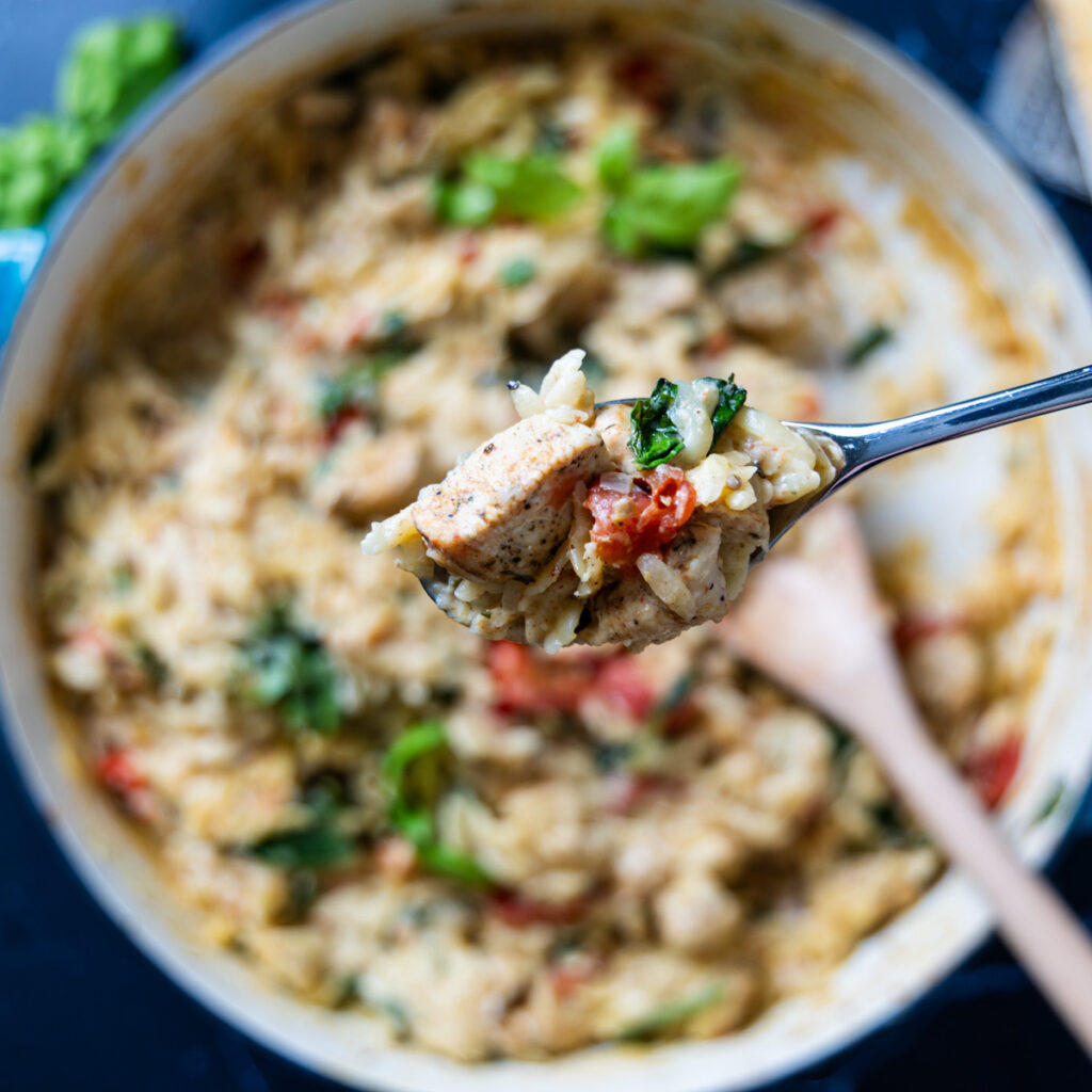 A skillet contains an orzo dish with a creamy sauce: One Pan Creamy Boursin Chicken Orzo